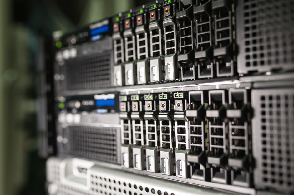 Imagem de um servidor de data center com múltiplas unidades de armazenamento e componentes tecnológicos avançados, representando infraestrutura de TI e tecnologia da informação.