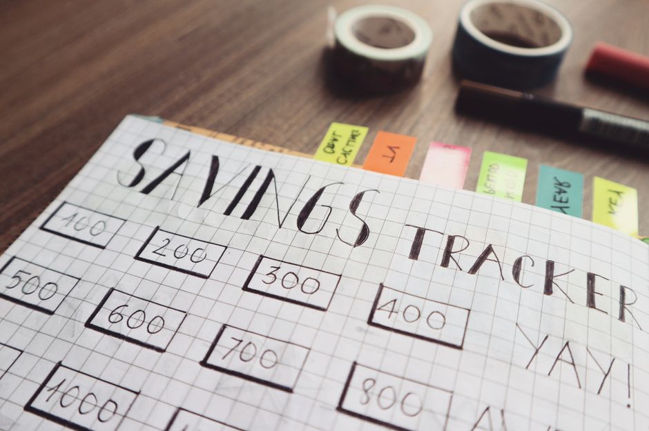 Página de planejamento financeiro mostrando metas de investimentos em uma agenda, com itens destacados e marcadores coloridos ao fundo.