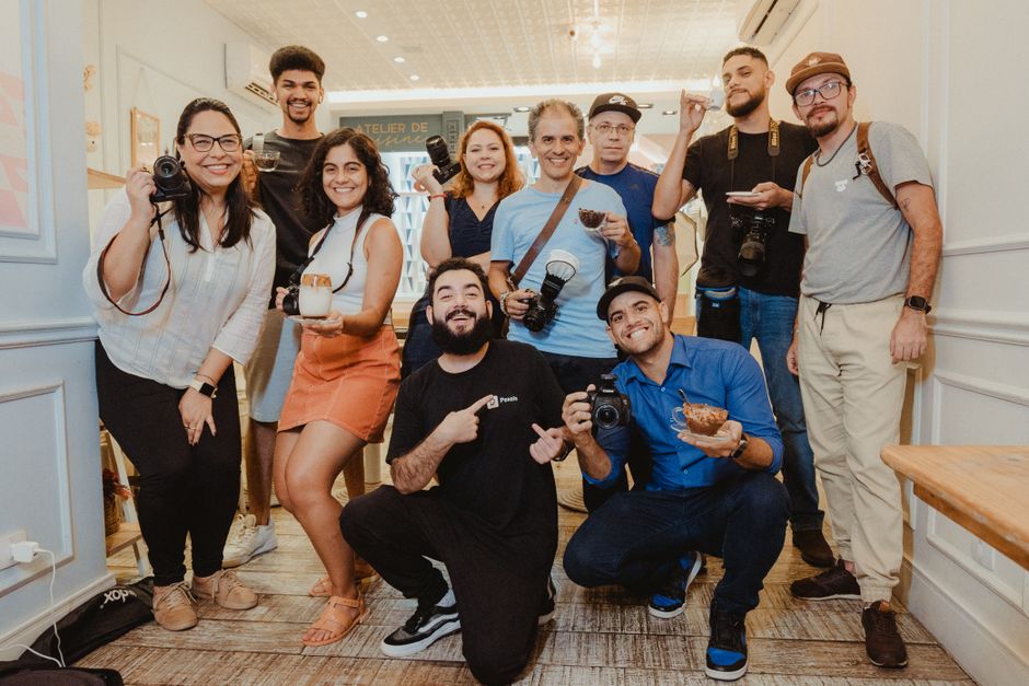Grupo de pessoas sorridentes reunidas em um ambiente interno, compartilhando momentos de convivência e alegria.