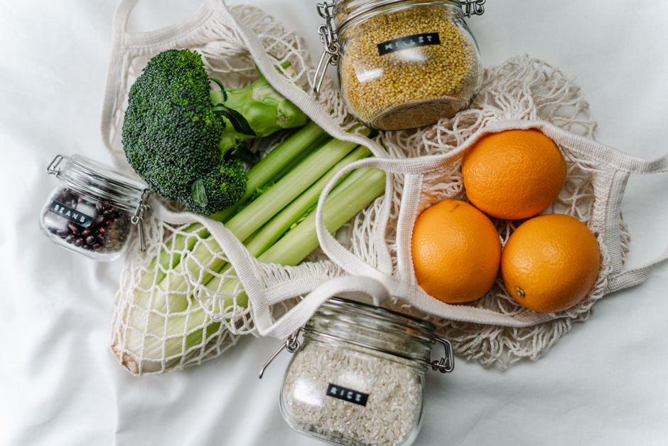 Imagem de alimentos saudáveis dispostos em uma rede de compras reutilizável, ideal para temas de alimentação consciente e sustentabilidade na alimentação.