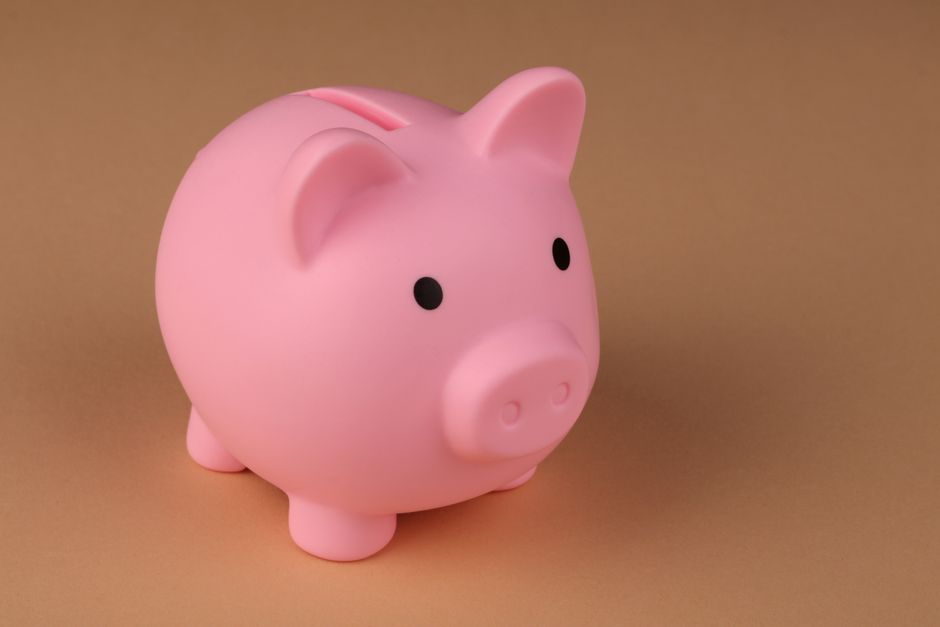 Imagem de um cofrinho de piggy bank rosa, símbolo de economia e finanças pessoais, em fundo neutro.