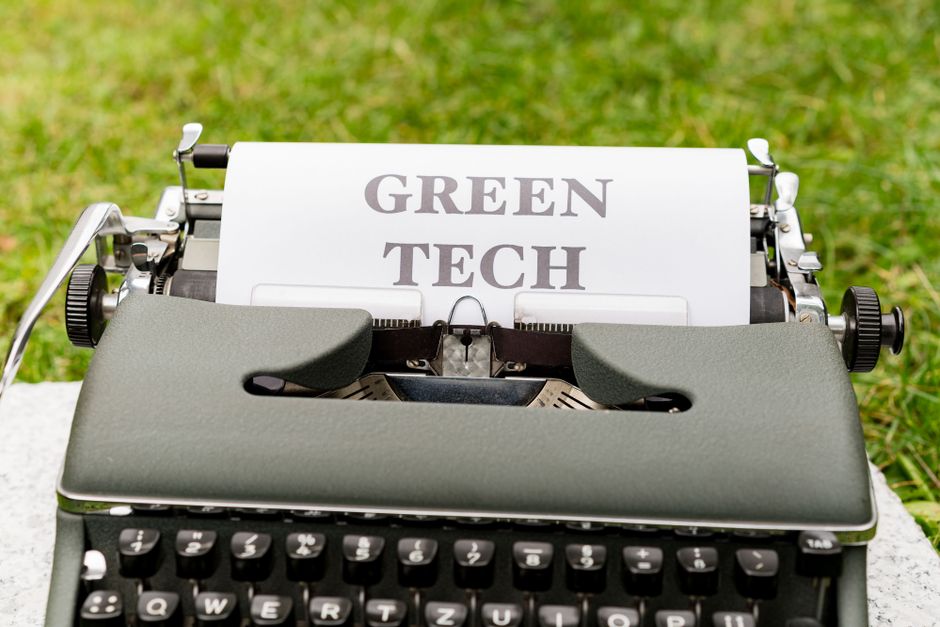 Uma máquina de escrever antiga com uma folha de papel escrito 'Green Tech', simbolizando inovação sustentável e tecnologia ecológica.