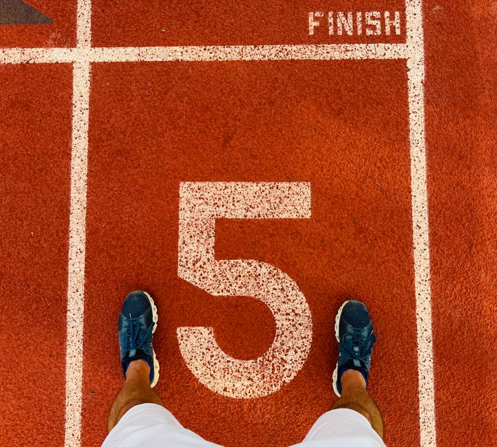 Imagem de um corredor de atletismo com o localizador no guia de partida, simbolizando preparação e início de desafios esportivos.