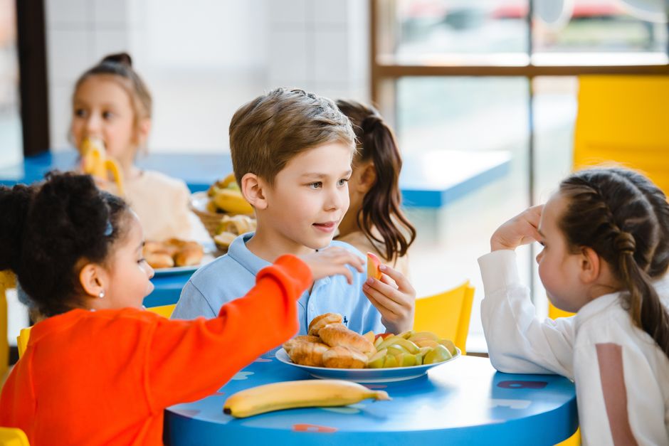 Crianças aprendendo sobre nutrição e alimentação saudável em um ambiente escolar ou de educação infantil.
