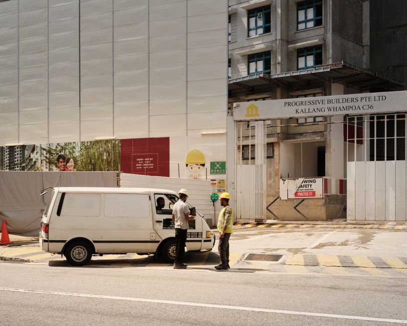 Profissionais da construção civil em discussão na obra de um prédio urbano em fase de construção.