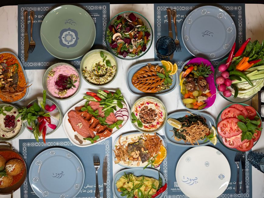 Mesa com uma variedade de pratos tradicionais e coloridos de uma refeição árabe ou mediterrânea, ideal para um almoço ou jantar em grupo.