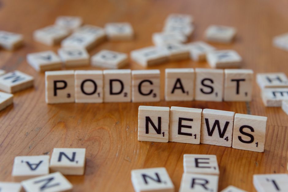 Imagem representando o conceito de notícias de podcasts, com blocos de palavras dispostos sobre uma superfície de madeira.