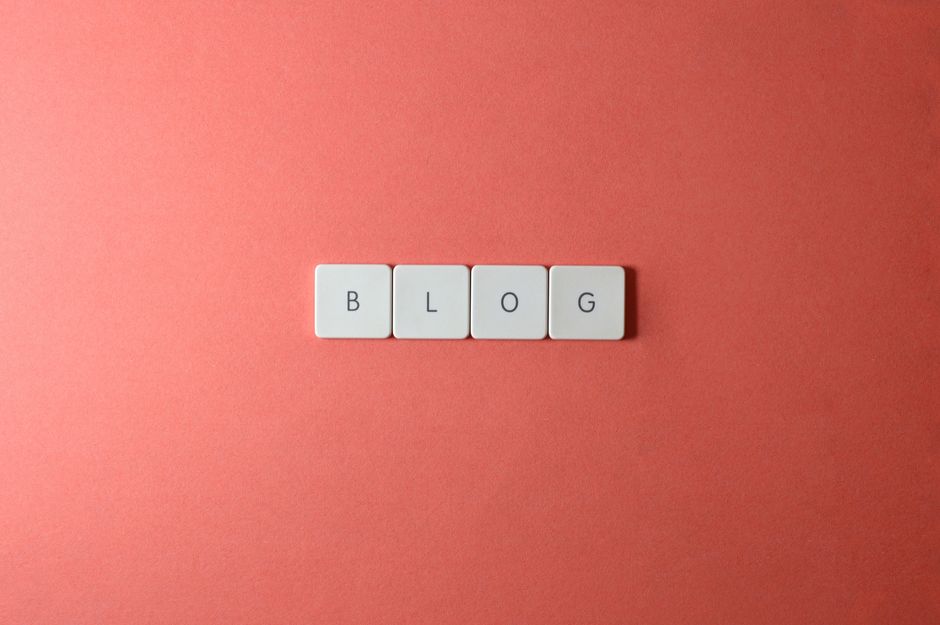 Imagem com blocos de letras formando a palavra 'BLOG' sobre um fundo de cor coral, ideal para ilustrar temas relacionados à criação e gestão de blogs ou conteúdo digital.
