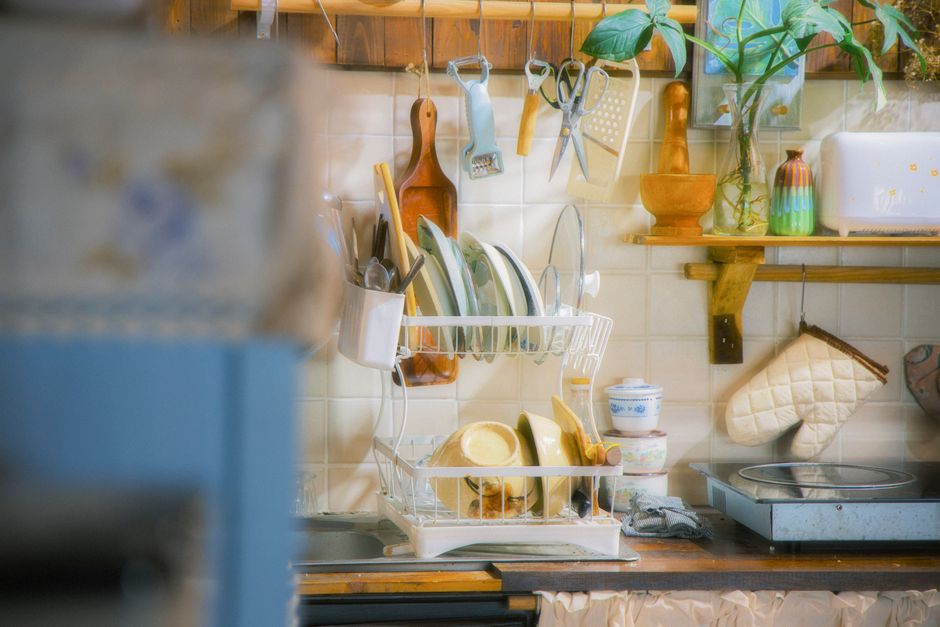 Imagem de uma cozinha organizada com utensílios de limpeza e decoração, ideal para ilustrar dicas de organização doméstica.