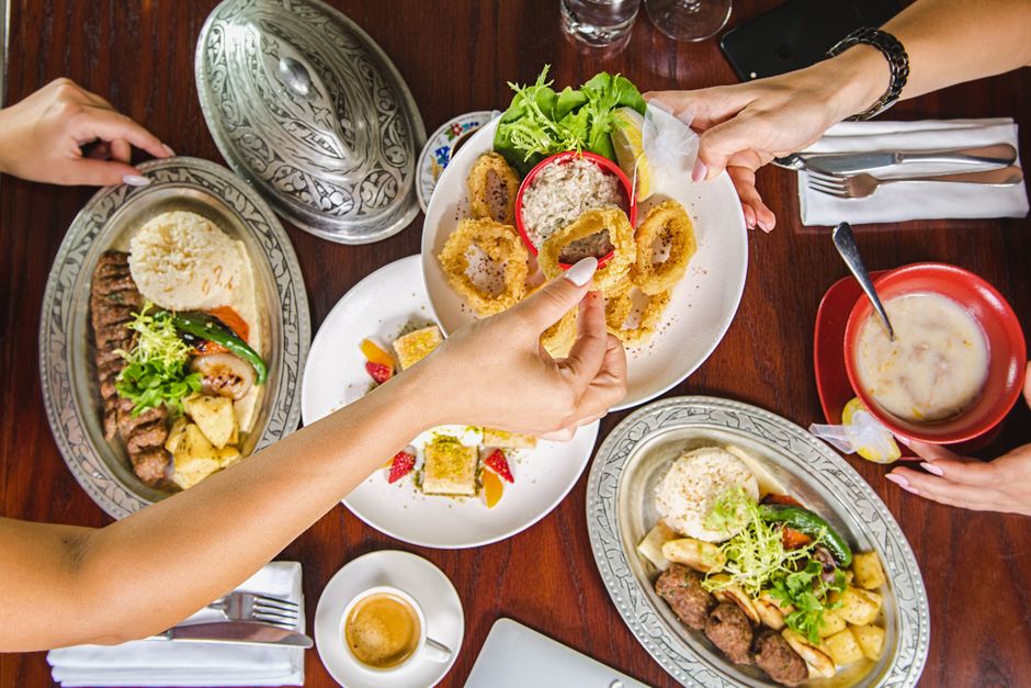 Refeição compartilhada com pratos tradicionais e decoração rústica em um ambiente de restaurante.