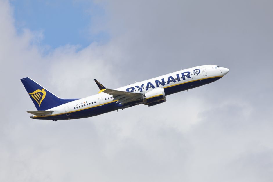 Avião comercial da Ryanair em voo, ilustrando viagens aéreas e turismo.