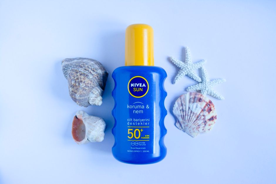 Protetor solar com foco na proteção contra raios UV durante o verão, acompanhado de conchas e estrelas do mar, ideal para blog sobre cuidados com a pele e viagens à praia.