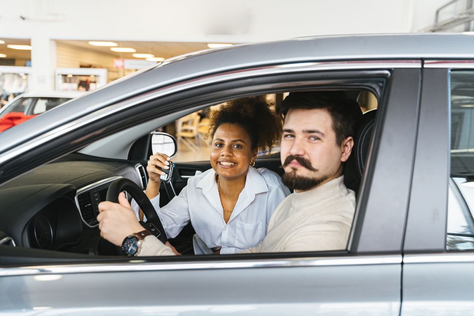 Mulher feliz recebendo as chaves do carro, simbolizando aquisição ou venda automotiva.