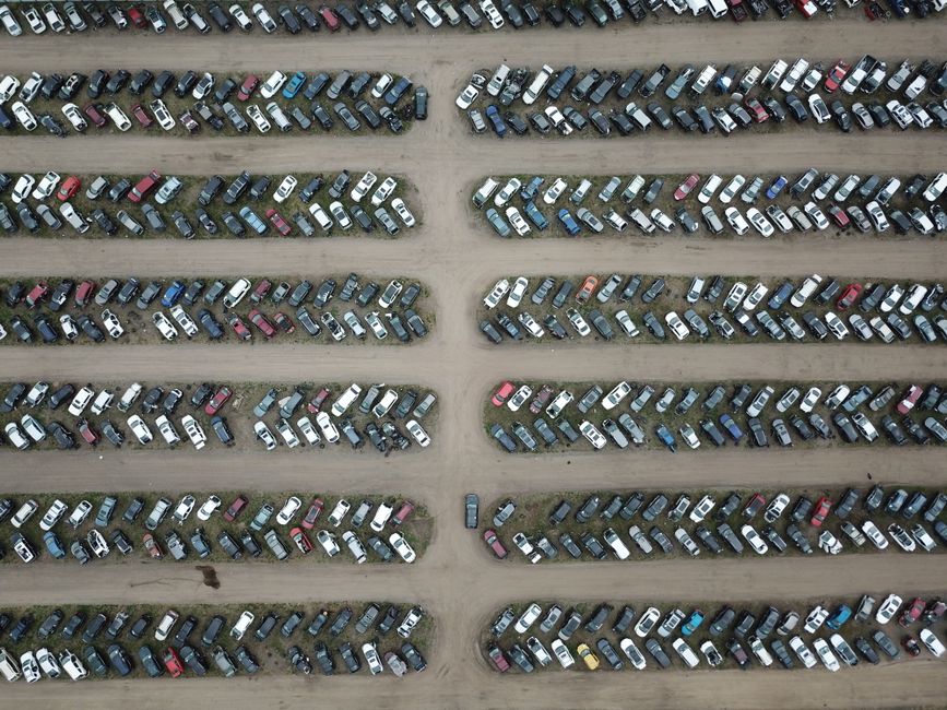 Imagem aérea de um estacionamento lotado, ilustrando a ocupação de veículos em uma área de acesso comum.