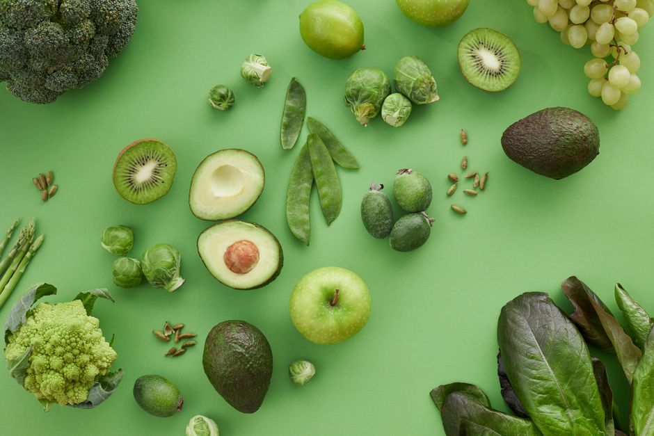 Imagem com variedade de frutas e legumes vegetarianos, destacando um tema de alimentação saudável e nutrição.