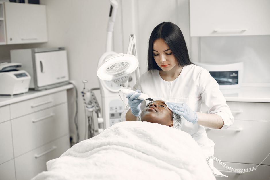Profissional realizando procedimento estético facial em uma clínica de beleza.
