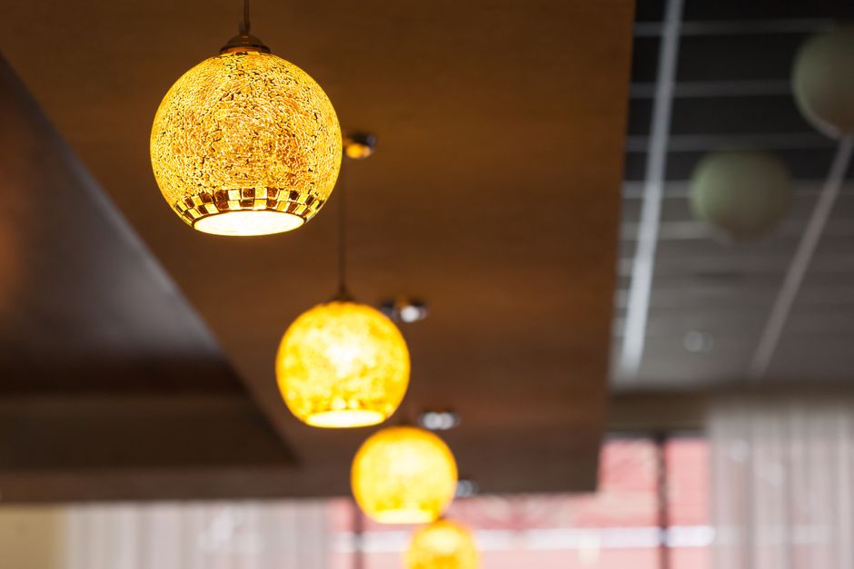 Lustres decorativos em um ambiente interno, criando uma atmosfera acolhedora e moderna para um espaço de convivência ou restaurante.