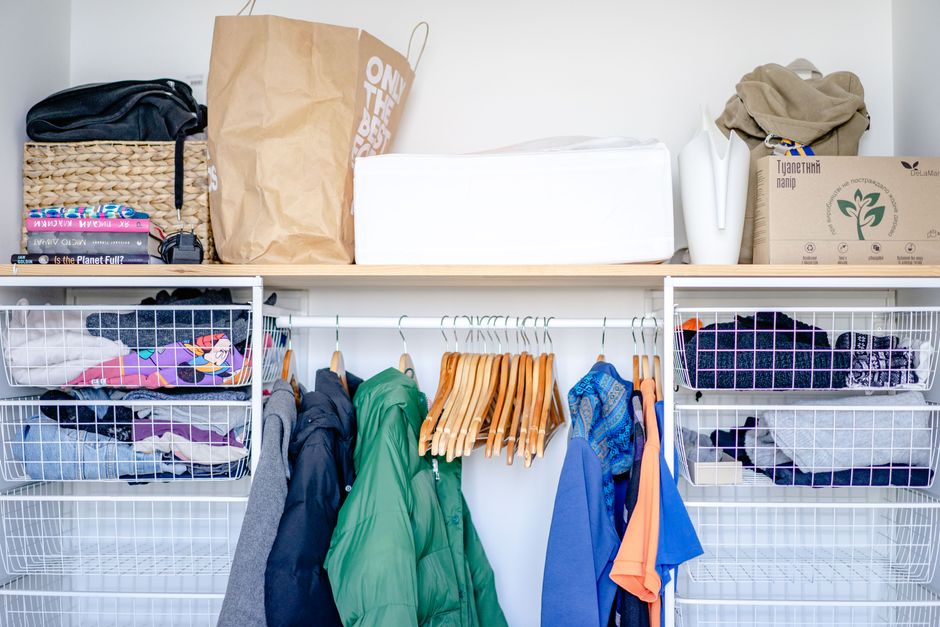 Organização de um armário com roupas e caixas de armazenamento, mostrando a organização do espaço doméstico.