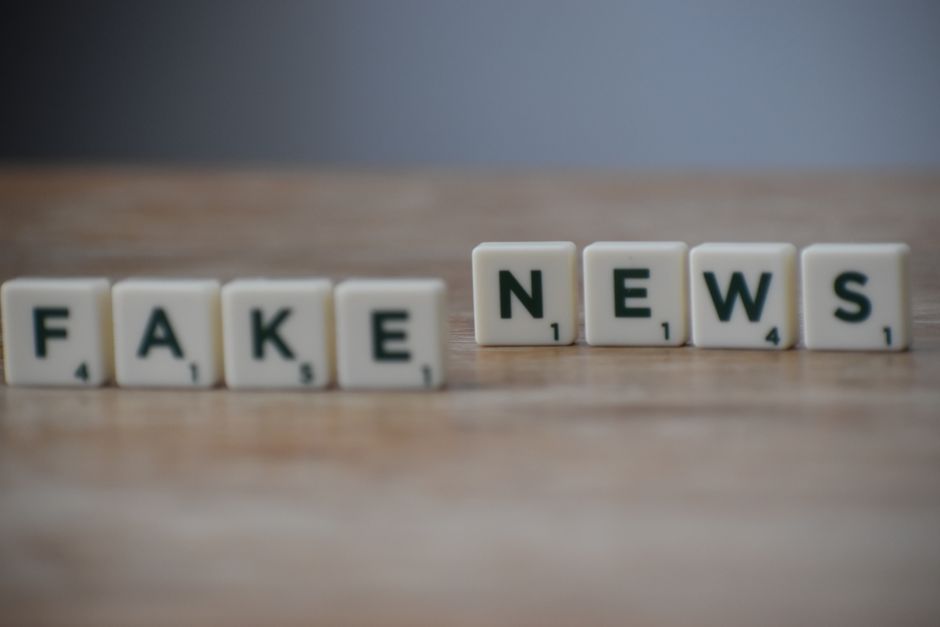 Imagem que destaca a importância de verificar a veracidade das informações na era digital, com blocos de montar formando a frase 'Fake News'.