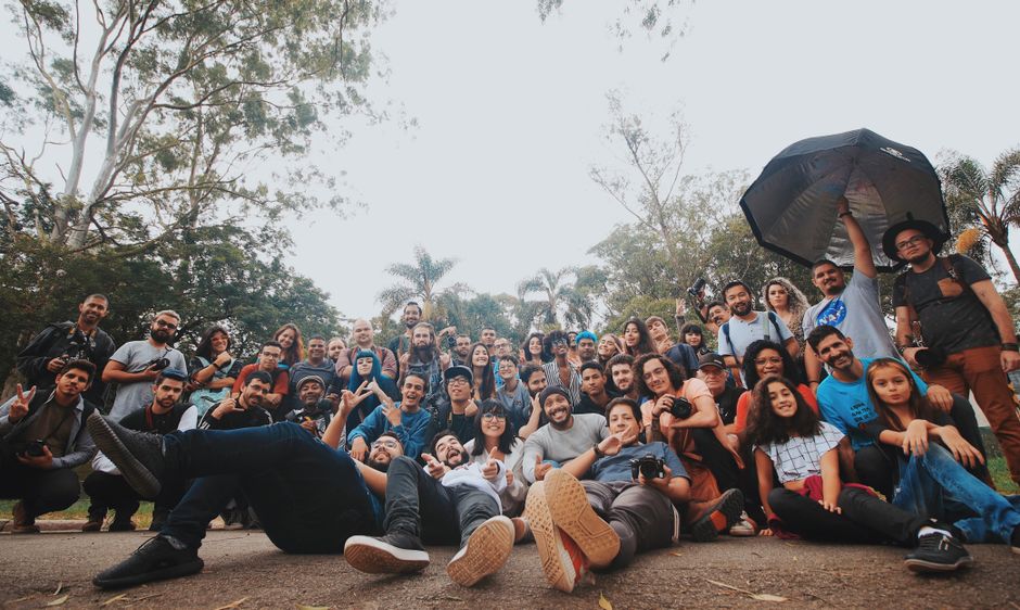 Grupo de pessoas reunidas ao ar livre, simbolizando colaboração e amizade em um ambiente natural.
