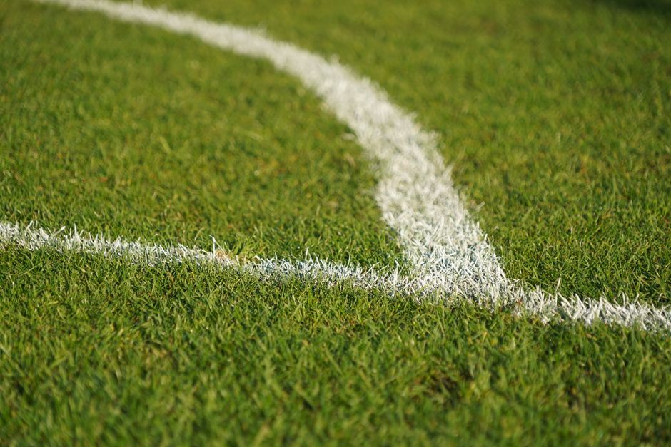 imagem de uma linha branca marcada no campo de futebol, representando o planejamento e estratégia esportiva.