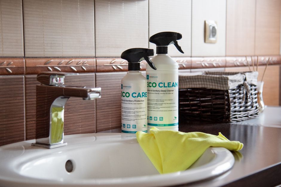 Imagem de uma pia de banheiro com produtos de limpeza e uma toalha, ideal para artigos sobre higiene e conservação de ambientes sanitários.