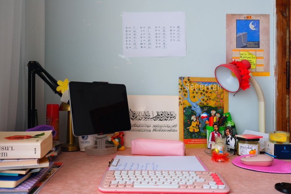 Estante de estudo ou trabalho jovem com livros, computador, artigos decorativos e materiais escolares em um ambiente de criatividade e aprendizado.