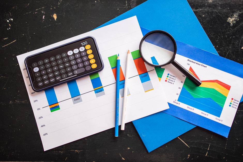 Imagem ilustrativa de análise financeira com gráficos, calculadora, e lupa, ideal para artigos sobre gestão de contas e tomada de decisão empresarial.