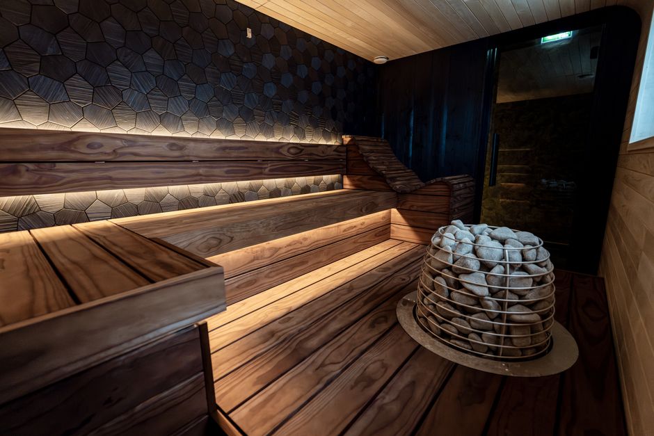 Imagem de uma sala de sauna com revestimentos de madeira e pedras modelo de relaxamento e bem-estar.