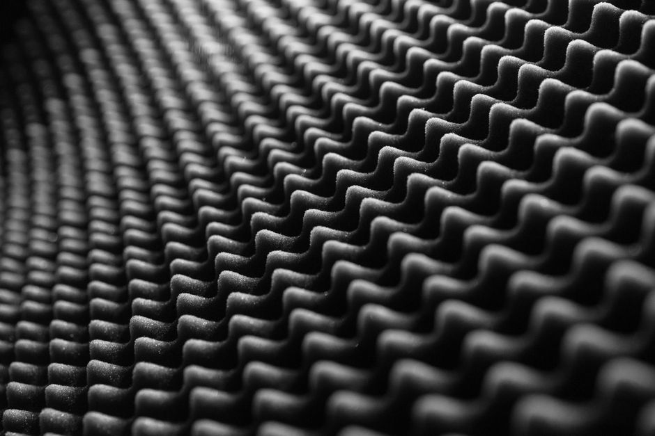Imagem de material acústico feito de espuma com design ondulado, usado para melhorar a qualidade sonora em ambientes internos.