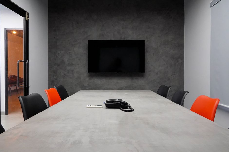 Sala de reuniões corporativa com televisão de tela plana e telefone, ideal para apresentações e reuniões de negócios.