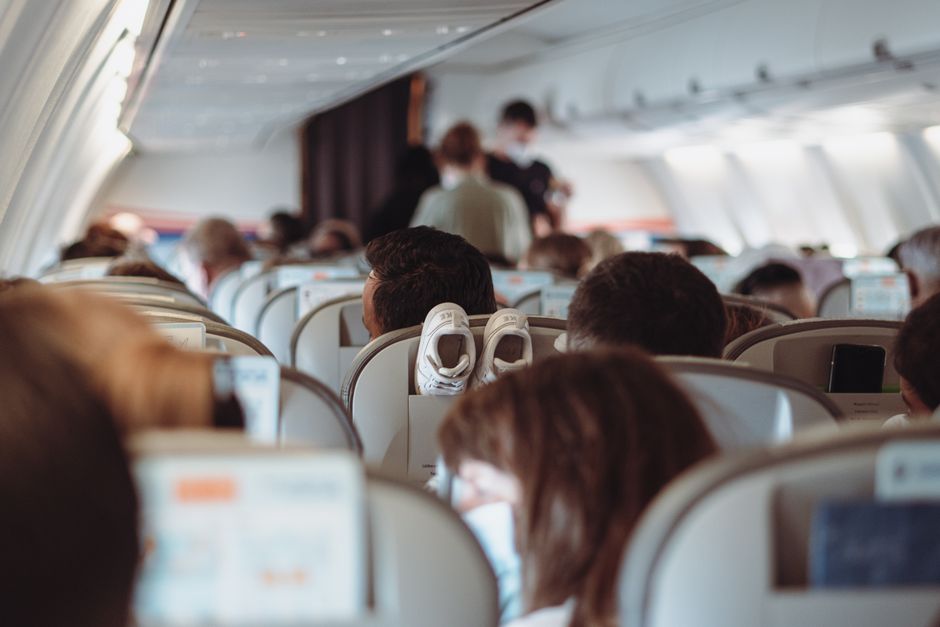 Imagem de passageiros em um avião, durante um voo comercial, com foco na atmosfera de viagem e transporte aéreo.