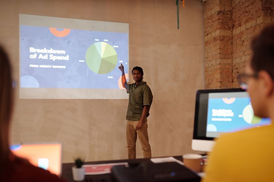 Homem apresentando dados de marketing digital em uma reunião de negócios. 