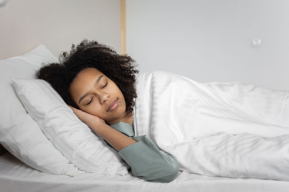 Mulher descansando na cama, representando importância do sono para o bem-estar e saúde mental.