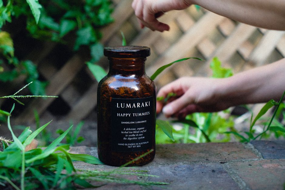 imagem de uma garrafa de lumináki com um fundo de jardim, sugerindo bem-estar e produtos naturais para uma publicação sobre saúde e lifestyle
