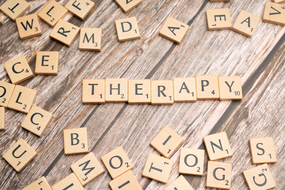 Imagem com peças de scrabble formando a palavra 'Terapia', representando temas de saúde mental e bem-estar emocional.