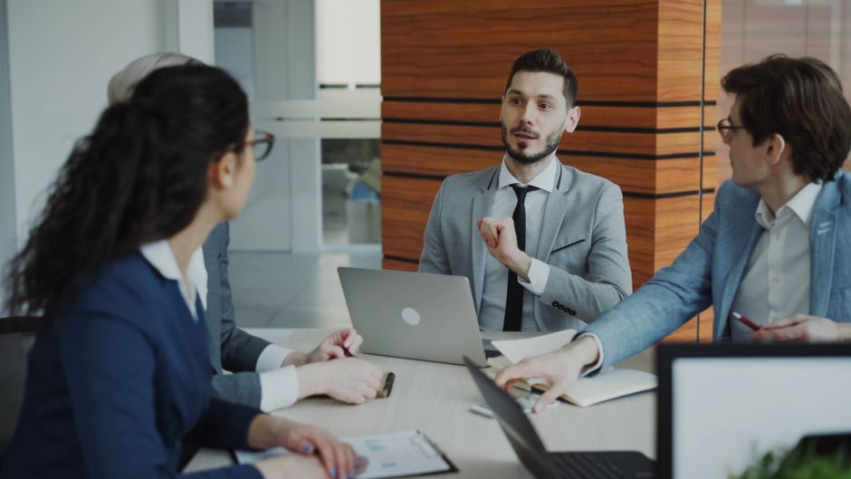 Grupo de profissionais em reunião de negócios discutindo estratégias e planejamento empresarial em ambiente corporativo.