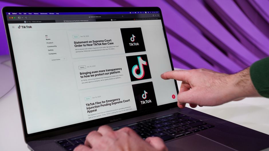 Pessoa navegando em plataforma de notícias ou conteúdo relacionado ao TikTok em um laptop, destacando o uso de tecnologia e redes sociais.