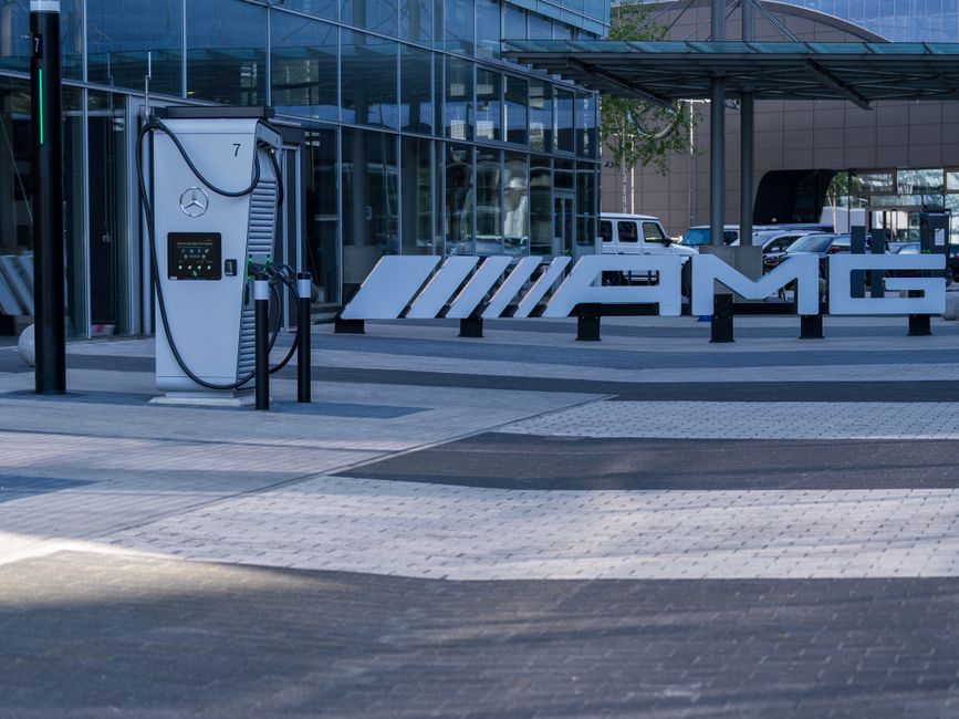 Estação de carregamento de veículos elétricos na fachada de uma concessionária de carros de luxo Mercedes-Benz AMG.