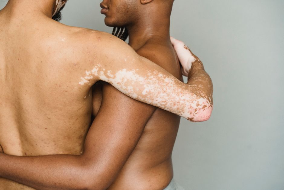 Homens de pele morena se abraçando, destacando a conexão emocional e a vulnerabilidade humana.