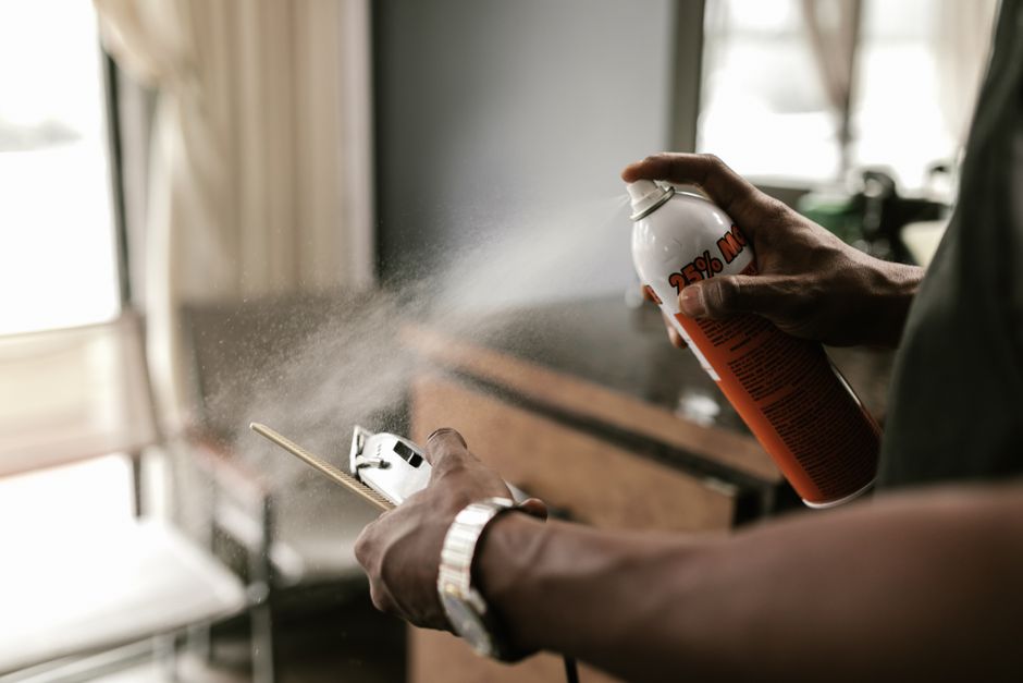 Pessoa usando spray de inseticida para eliminar pragas, simbolizando a solução de problemas de infestação.