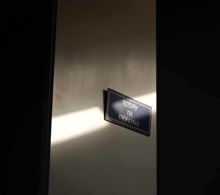 Placa indicando que a pessoa está offline, simbolizando ausência ou pausa no trabalho.