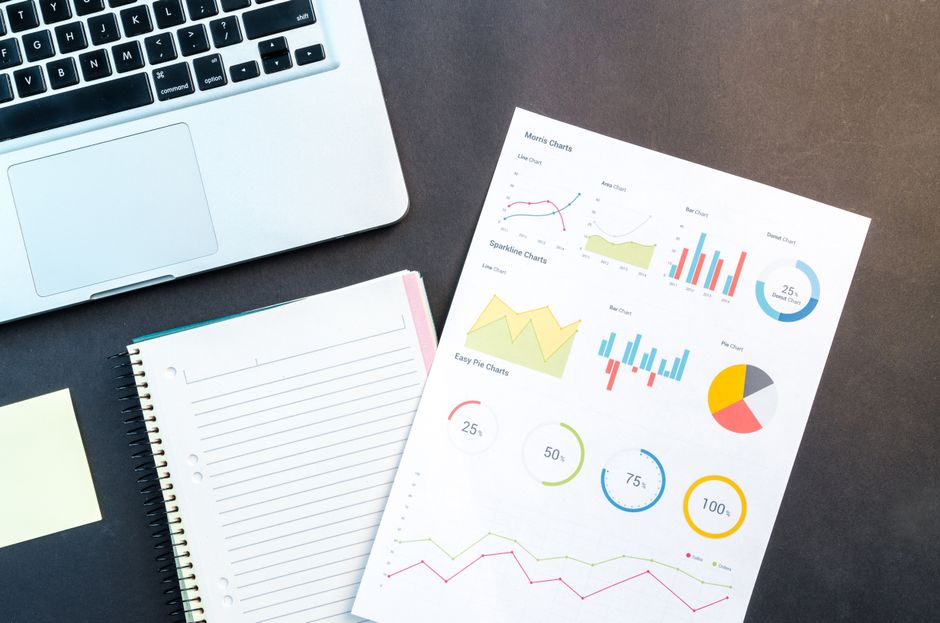 Imagem ilustrando análise de dados financeiros e planejamento estratégico em ambiente de trabalho com recursos de análise gráfica e documentação.