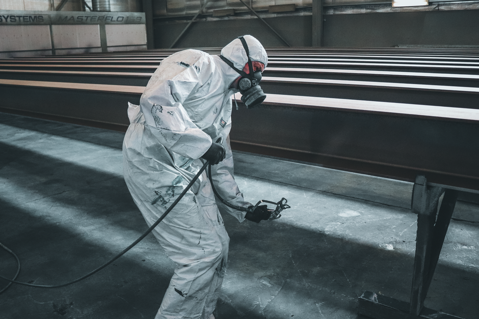 Profissional de proteção ambiental realizando inspeção em estrutura metálica em ambiente industrial, destacando o tema de segurança e sustentabilidade.
