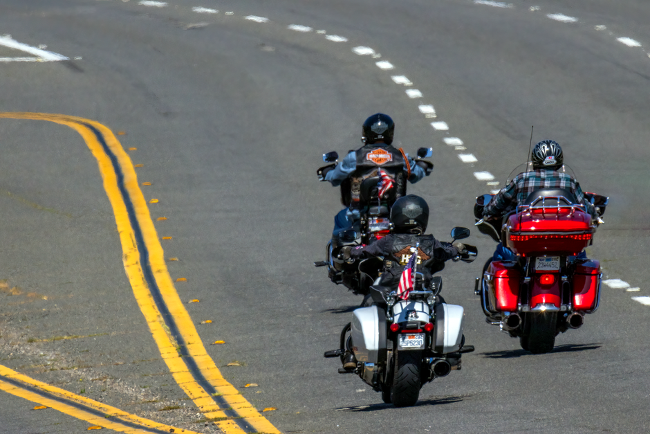 Grupo de motociclistas percorrendo uma estrada, representando aventura e liberdade em viagens sobre duas rodas.