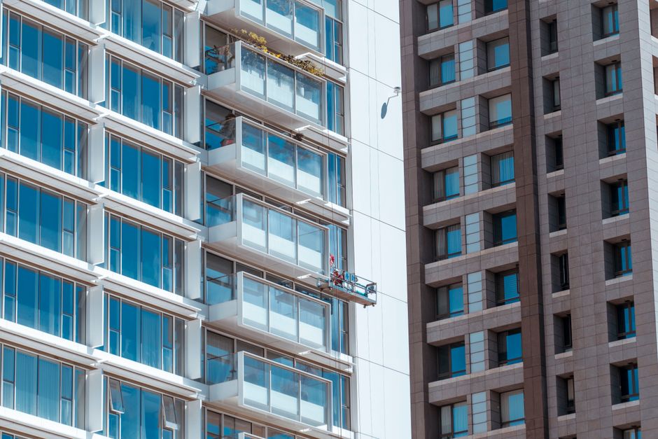 Imagem de um edifício de alta torre com uma janela de vidro grande, refletindo o céu, simbolizando inovação e urbanismo, ideal para artigos sobre arquitetura moderna ou desenvolvimento urbano.