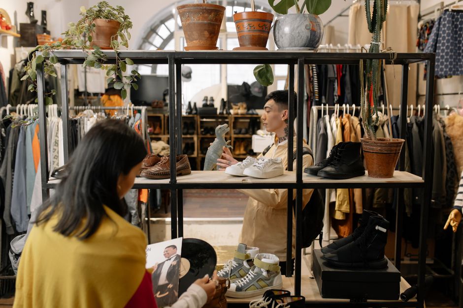Imagem de uma loja de roupas vintage com manequins exibindo calçados e acessórios, destacando o universo de moda sustentável e estilo retrô.