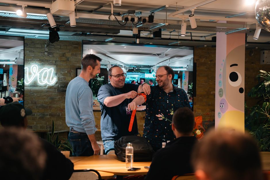 Homens celebrando em ambiente de coworking, simbolizando colaboração e amizade profissional.