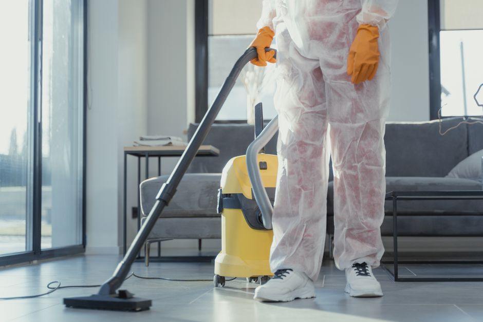 Profissional realizando limpeza com aspirador de pó em ambiente residencial moderno.