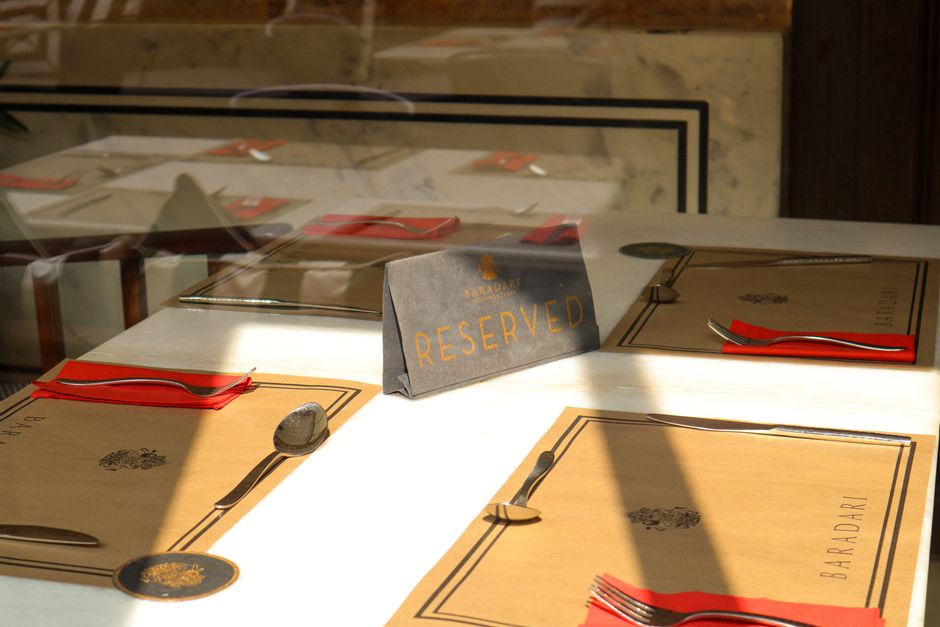 Mesa de restaurante reservada com utensílios e menus elegantes, pronta para receber clientes em um ambiente sofisticado.